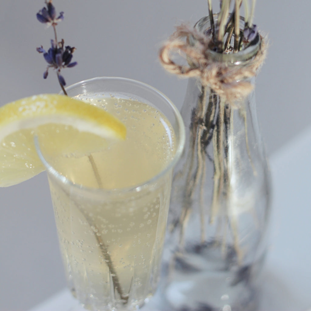 Lavender Bubbly Bath cocktail up close beside a bouquet of dried lavender